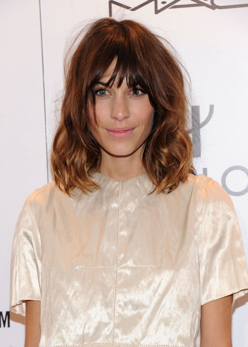 Alexa Chung w kremowej kreacji na ściance na evencie marki MAC