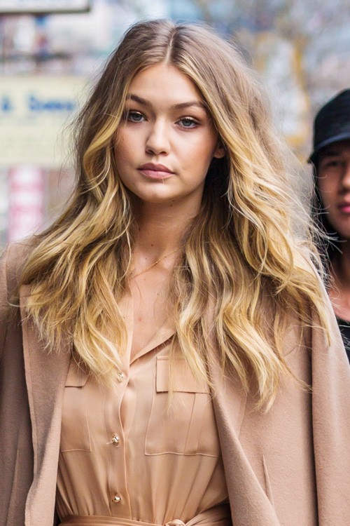 Modelka Gigi Hadid w blond teksturyzowanychfalalch i kremowym płaszczu