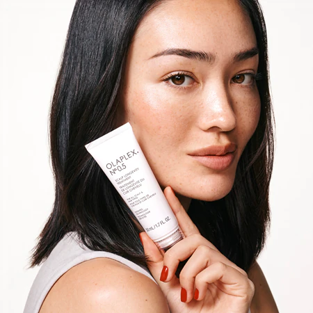 Kobieta trzymająca w dłoni serum do skóry głowy Olaplex 0.5 Longevity